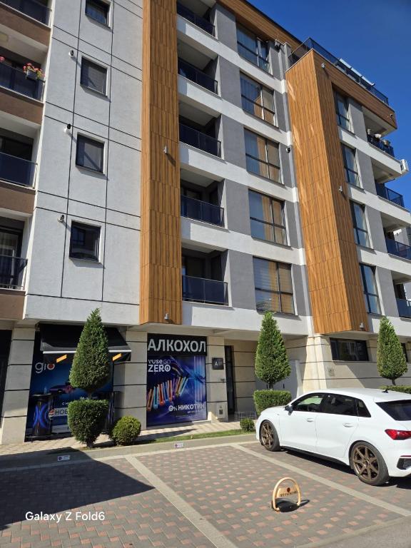 a white car parked in front of a building at Diljanka 4 in Pernik