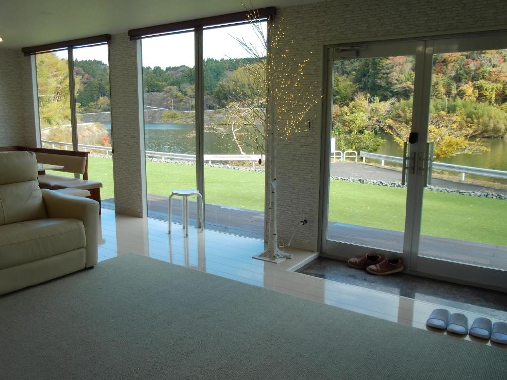 a living room with a couch and large windows at 平沢リゾート in Ōtaki