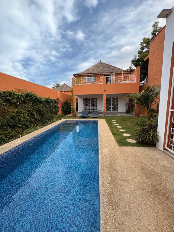 a swimming pool in front of a house at Villa John et Nini in Saly Portudal