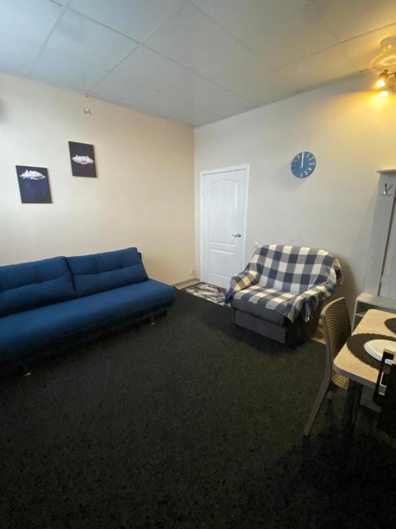 a living room with a blue couch and a bed at МотельХаусSous in Svitlovodsʼk