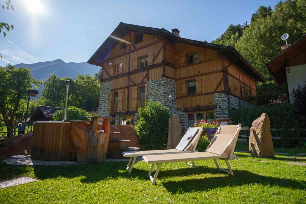 a bench in the grass in front of a house at Appartamenti Chalet Canedi in Peio