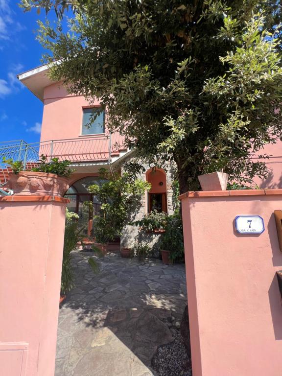 a pink house with a tree in front of it at Bilocale il Rosmarino in Portoferraio