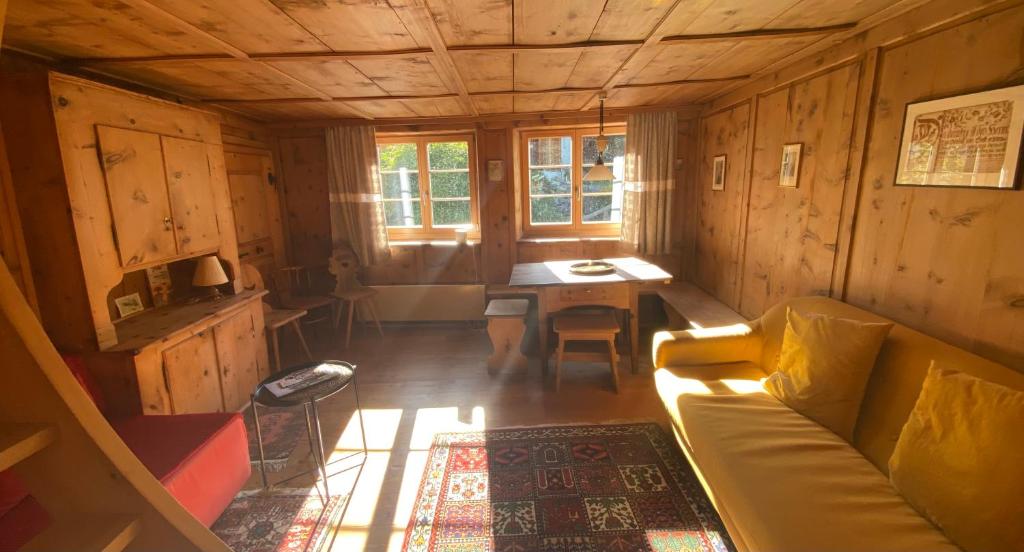 a room with a couch and a table in a cabin at Arvenstube - Wergenstein in Wergenstein