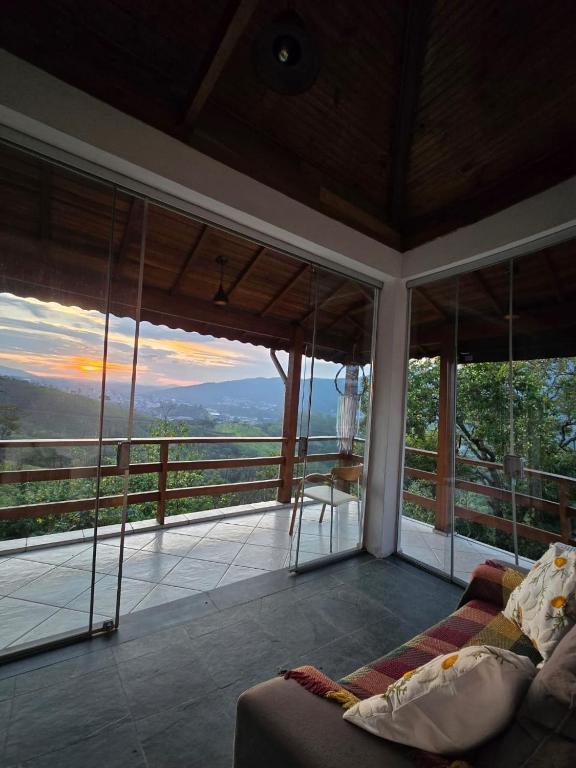 a living room with a couch on a balcony at Refúgio da Zena in Mairiporã