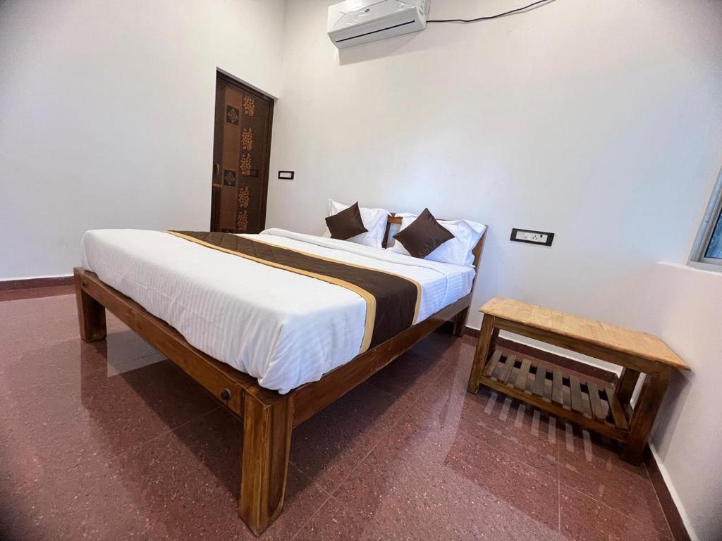 een slaapkamer met een groot bed met witte lakens bij VVR Residency in Kuilapayam