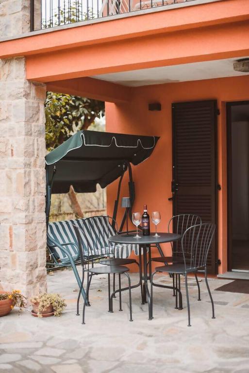 a table and chairs with an umbrella on a patio at Villa bif. nel verde tra Bobbio/Grazzano/1h Milano in Viserano