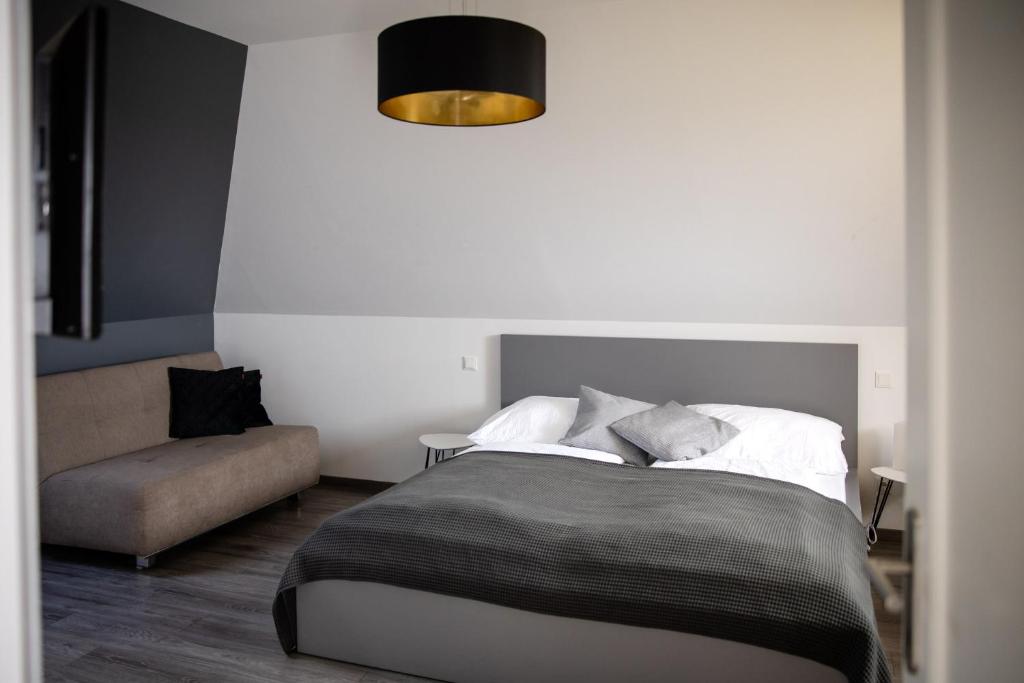 a bedroom with a bed and a couch at Strommer wine das Gästehaus in Purbach am Neusiedlersee