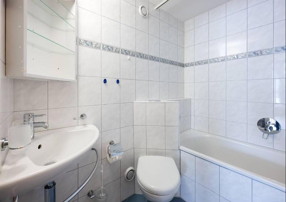 un bagno bianco con un water e un lavandino di WEF Davos - Private Room in Shared Apartment a Davos