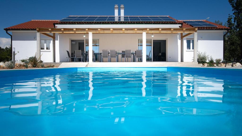 a house with a swimming pool in front of it at Villa Cyprian by Villas Guide in Kampor