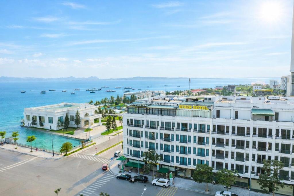 an aerial view of a large white building next to the water at River Hotel Hạ Long in Ha Long