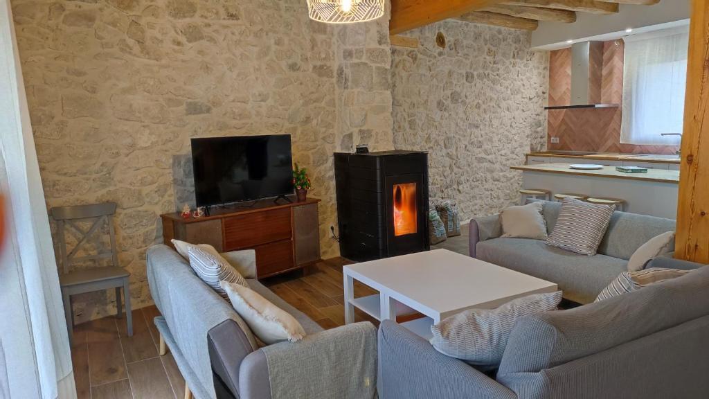 a living room with couches and a tv and a fireplace at La Cantizada in Viloria