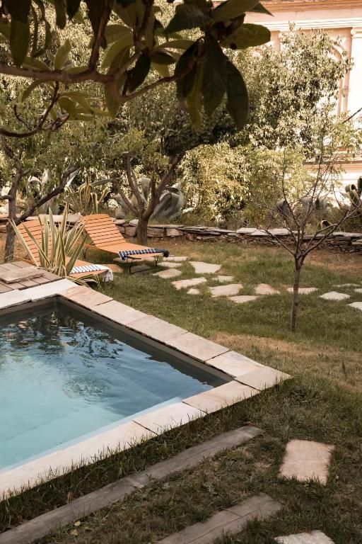 a swimming pool in a yard with a chair at Montera appartement centre ville avec piscine chauffée et jardin in Bastia