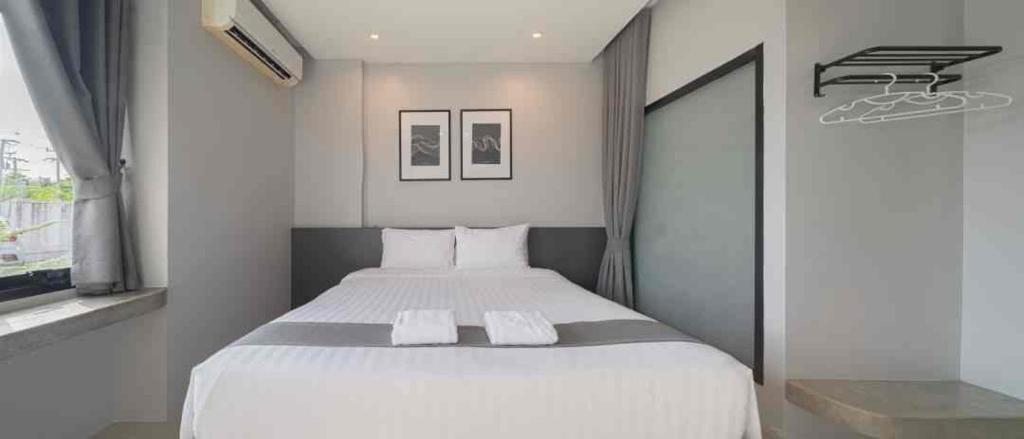 a bedroom with a large bed with two towels on it at ซีทูยู อุทัยธานี in Ban Wang Yang