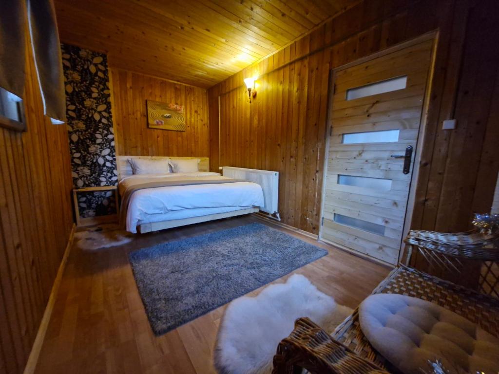 een slaapkamer met 2 bedden in een houten kamer bij Cabana din Padurea Valeni in Vălenii de Munte