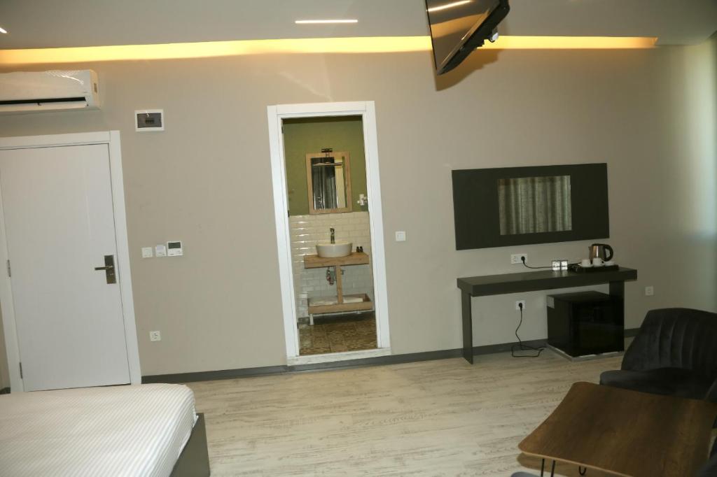 a bedroom with a bed and a desk and a mirror at zoom hotels in Eskiömerler