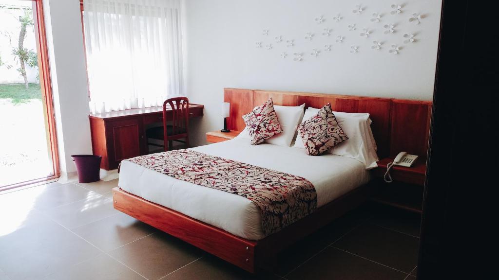 a bedroom with a bed and a large window at Hotel Belén Boutique in Manizales