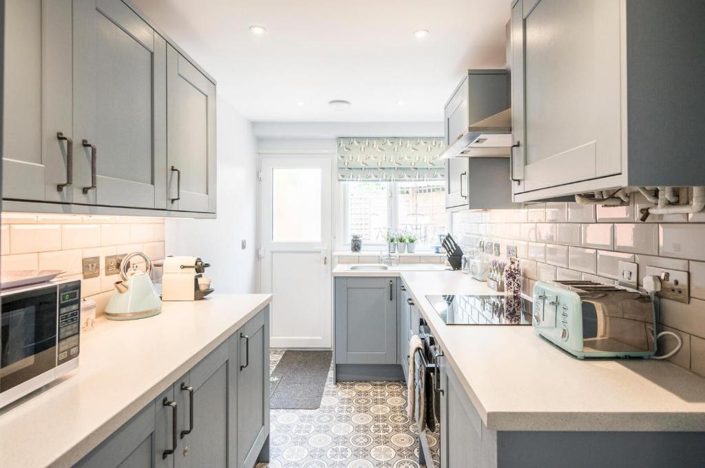 a kitchen with white cabinets and a sink at 1 Lavender Cottages, Knodishall in Saxmundham