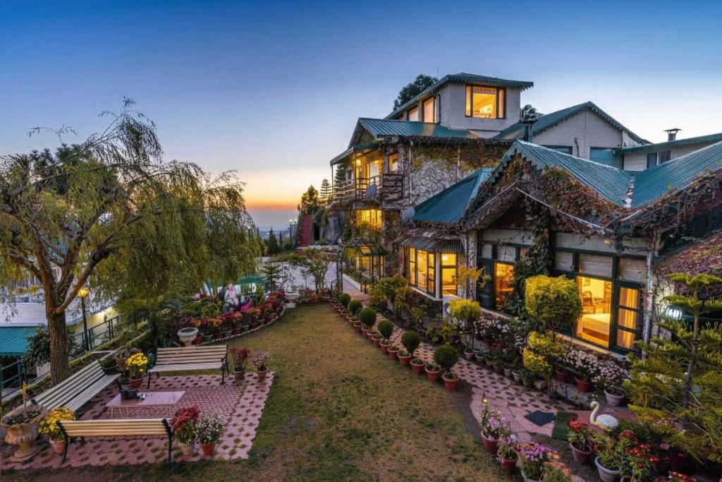 a large house with benches in front of it at Villa Mountain Crest Kasauli with Treehouse , Sundeck & Breakfast in Dagshai