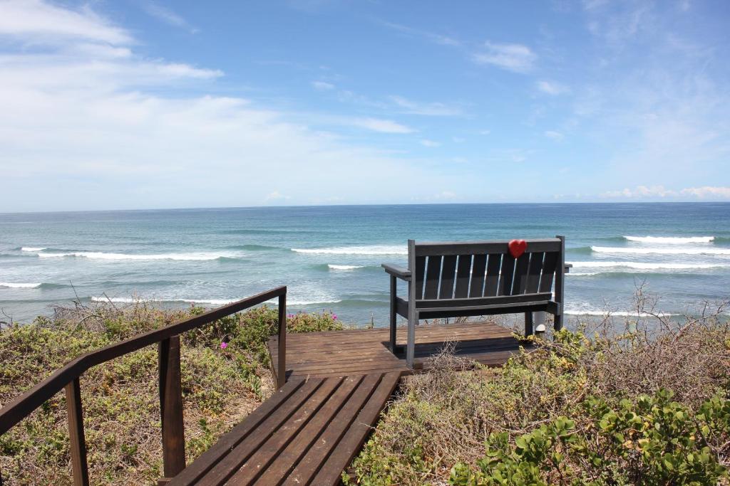 a bench sitting on top of a boardwalk near the ocean at Seas the Breeze in Boknes