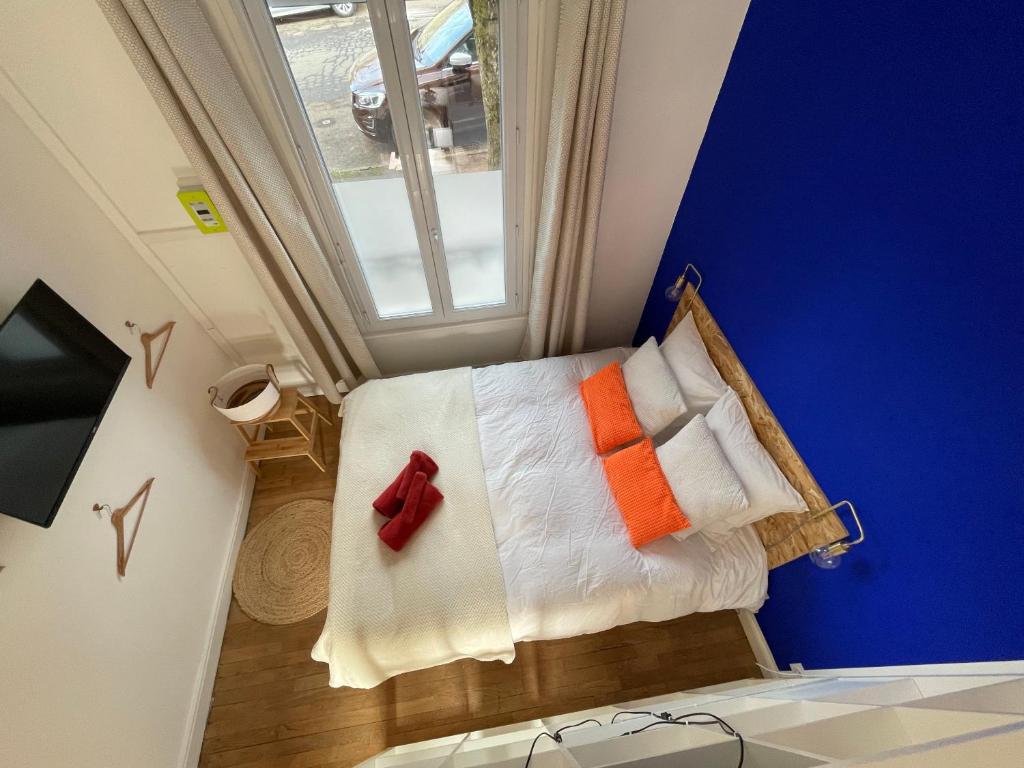 een kleine kamer met een bed met kleurrijke kussens bij Maison Yuki - Bleu Alpin - Netflix & Parking gratuit in Le Mont-Dore