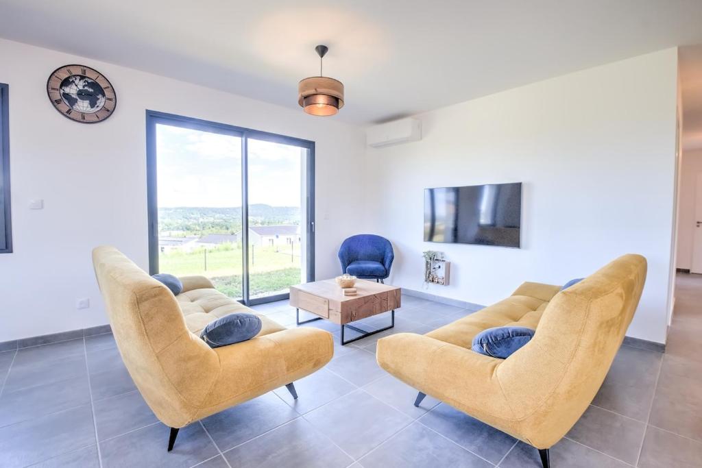 un soggiorno con sedie, TV e tavolo di Sunset villa a Trélissac