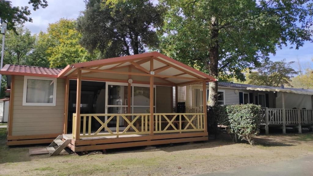 a small house with a screened in porch at Chalet KABANA in Saint-Hilaire-de-Riez