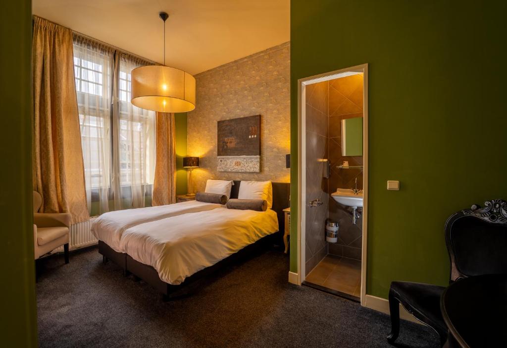 a bedroom with a large bed and a mirror at De oude gevangenis Almelo in Almelo