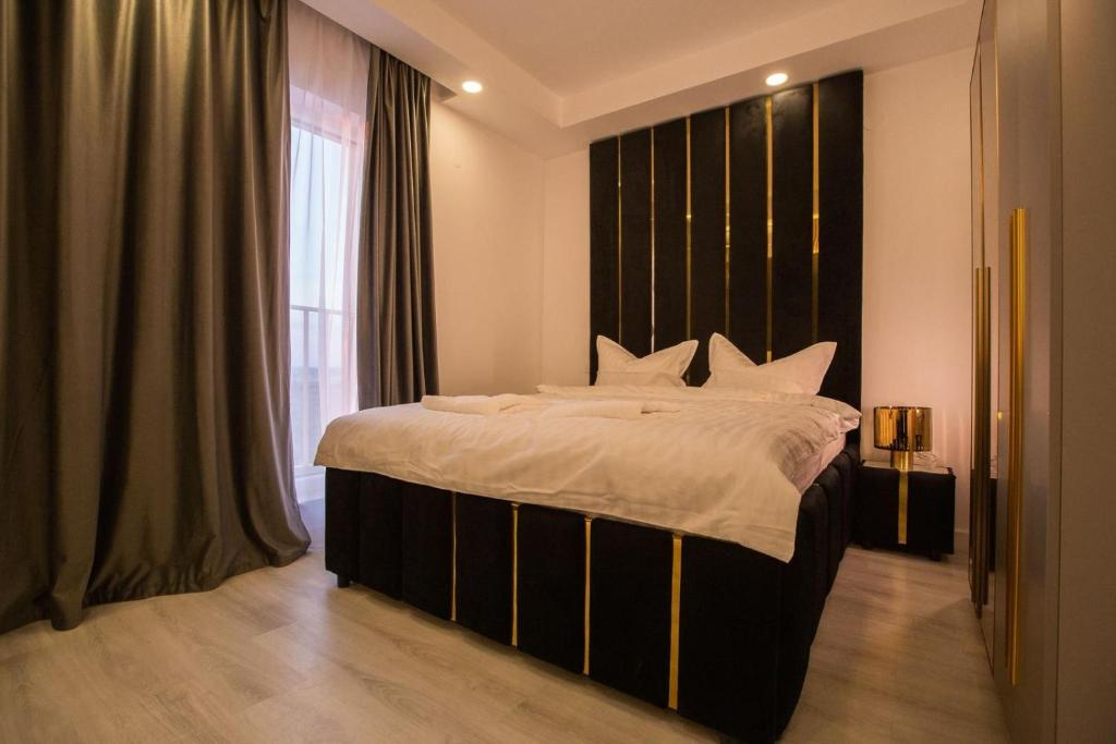 a bedroom with a large bed and a large window at Klaus Luxury Apartment #Bucharest in Ştefăneştii de Sus