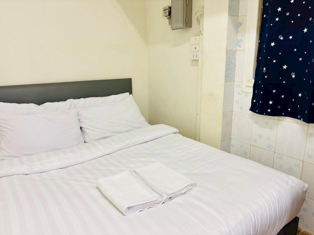 a white bed with two white towels on it at BKK Rama3 Guest House in Bangkok