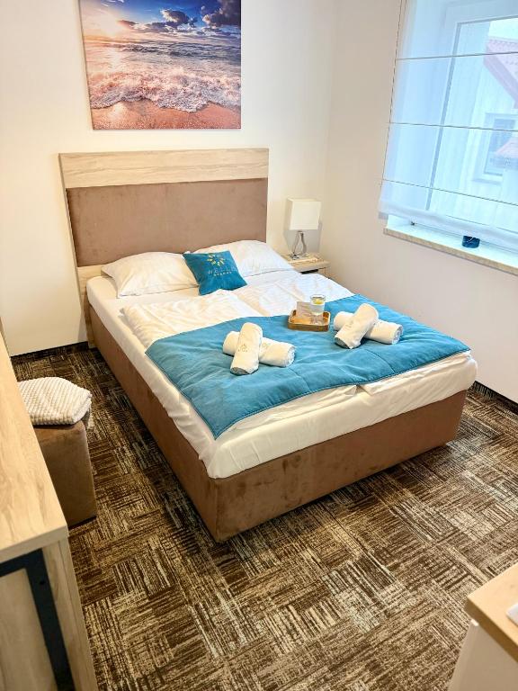 a bedroom with a bed with towels on it at Al-Dom Apartamenty, SUN w Welle z dostępem do sauny i jacuzzi in Grzybowo