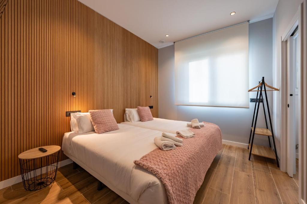 a bedroom with a bed with towels on it at White Tree Rooms and Apartments in O Pedrouzo