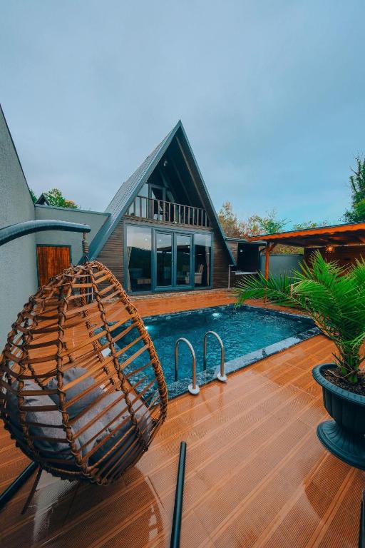 a wicker basket sitting on a deck next to a swimming pool at Sapanca Ruby Bungalow in Sapanca