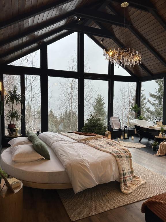 a large bed in a room with a large window at Noma Cabin in Măguri