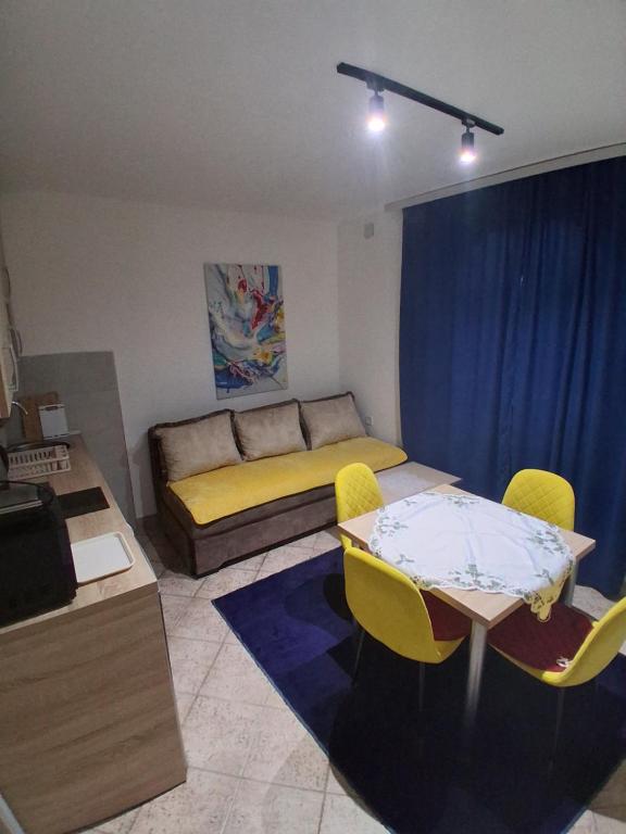 un soggiorno con un letto, un tavolo e delle sedie di apartman19 a Podgorica