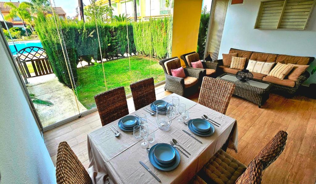a table and chairs in a living room with a patio at Pura Vida in Lepe