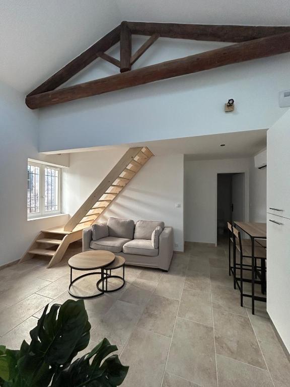 a living room with a couch and a table at La maison du Quart - Maison de village in Sommières
