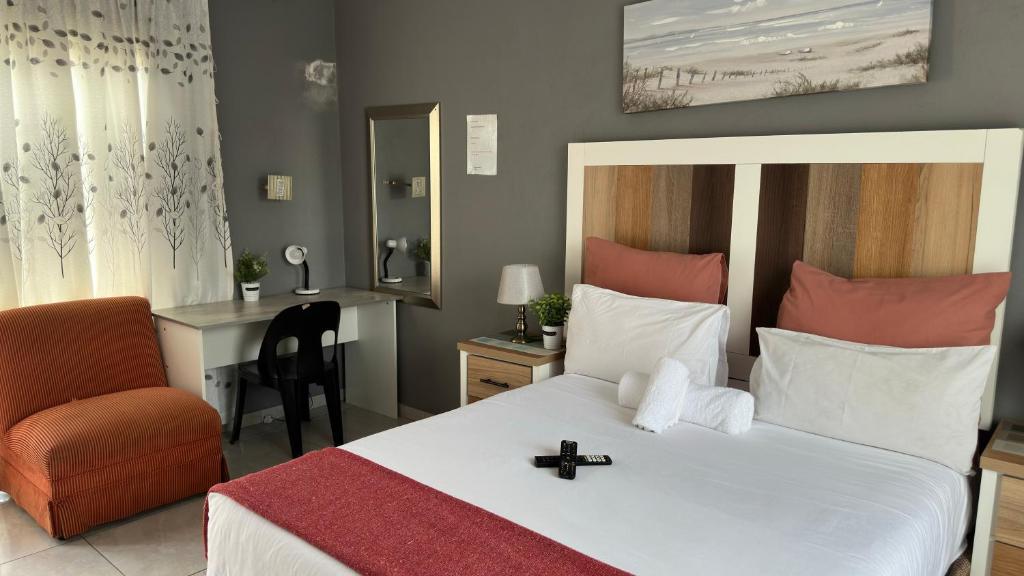 a bedroom with a bed and a chair and a desk at K K K Guesthouse in Secunda