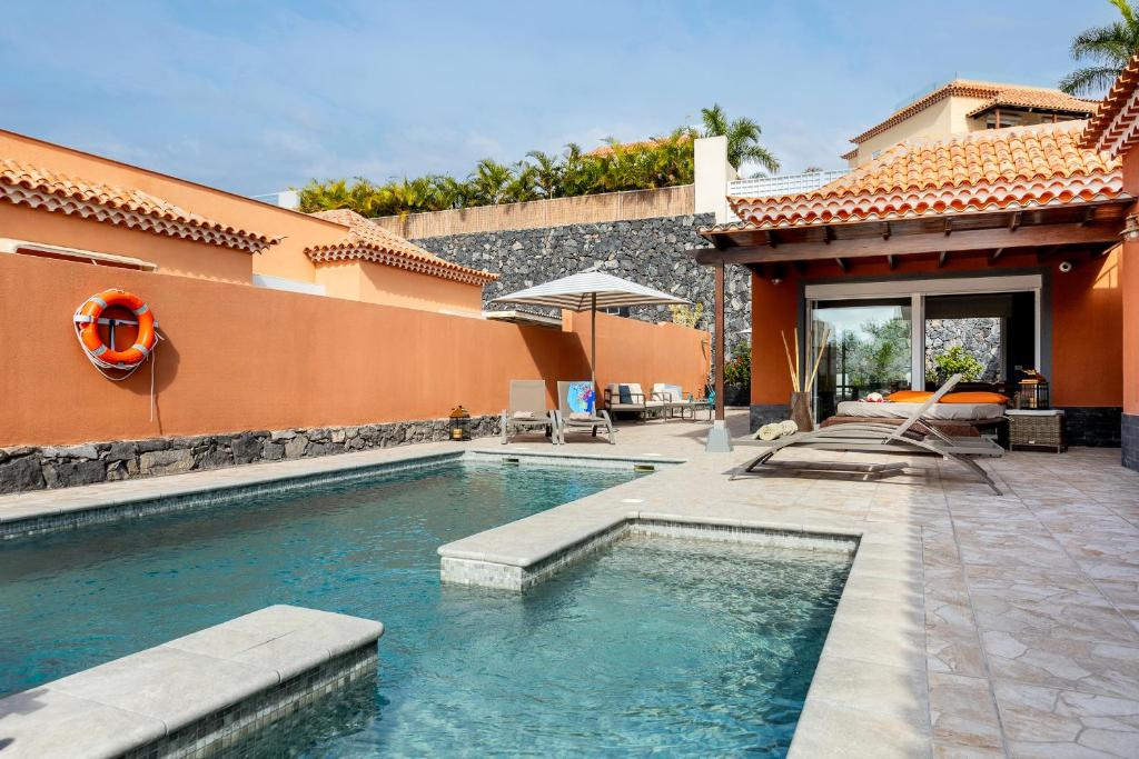a swimming pool in front of a house at Villa Cornelia in Adeje