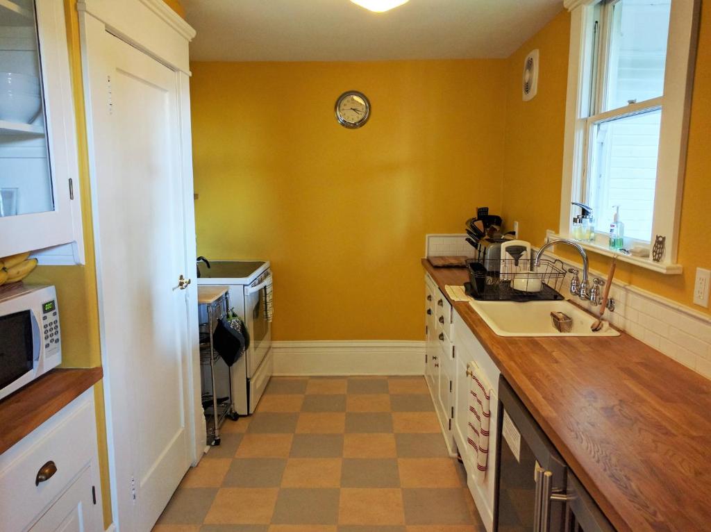 a kitchen with a sink and a clock on the wall at Evermore Guesthouse in Portland
