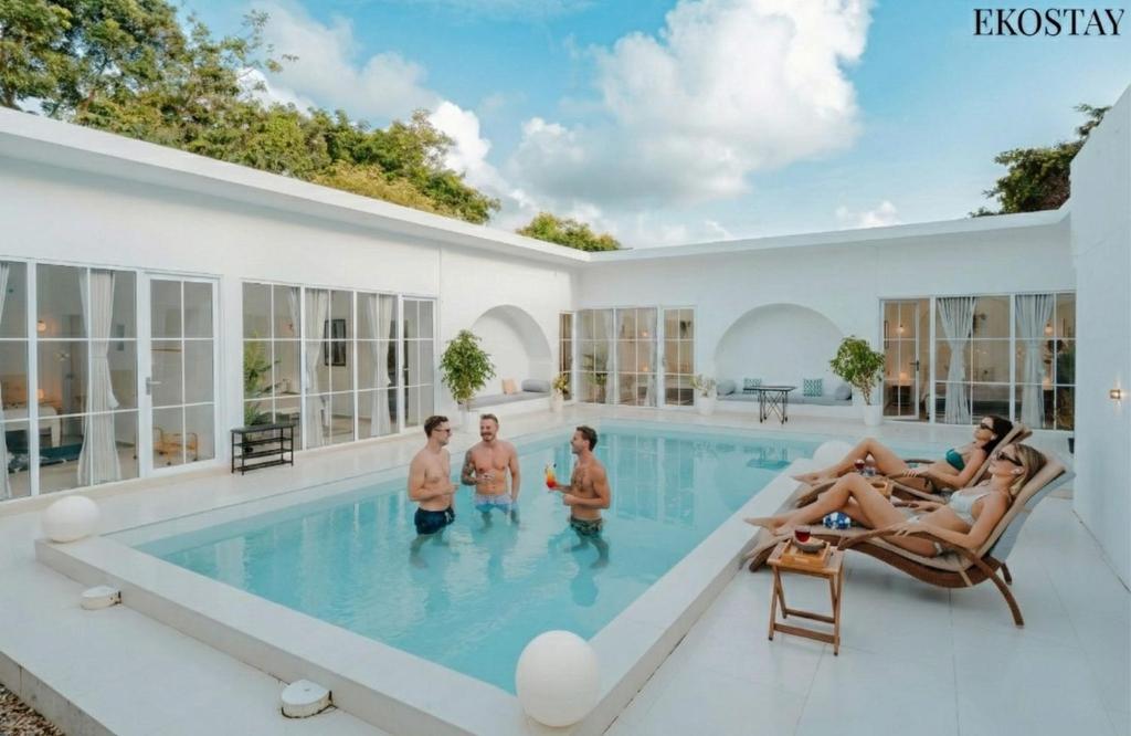 een familie in het zwembad van een huis bij EKOSTAY Gold - Ark Stone Villa in Alibaug