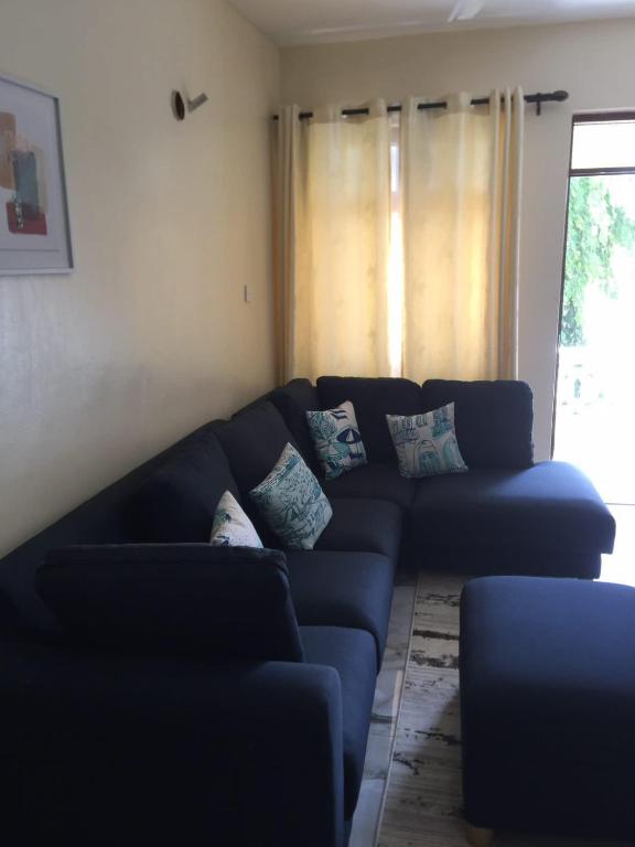 a blue couch in a living room with a window at Jowi homes in Mtwapa