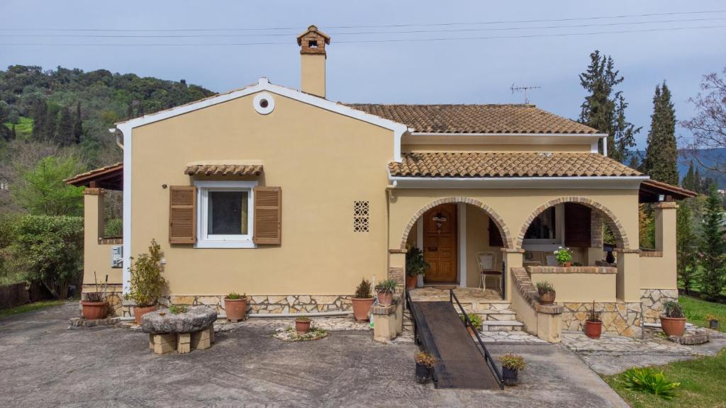a small yellow house with a porch at Villa Haris in Gazátika