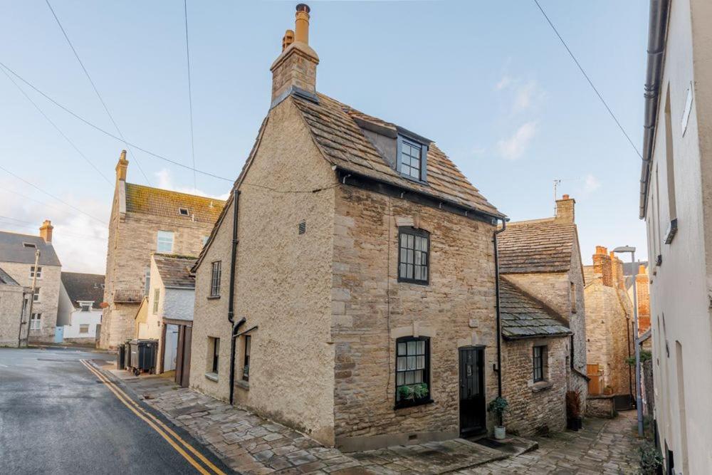 an old stone building on the side of a street at Olive Cottage in Swanage