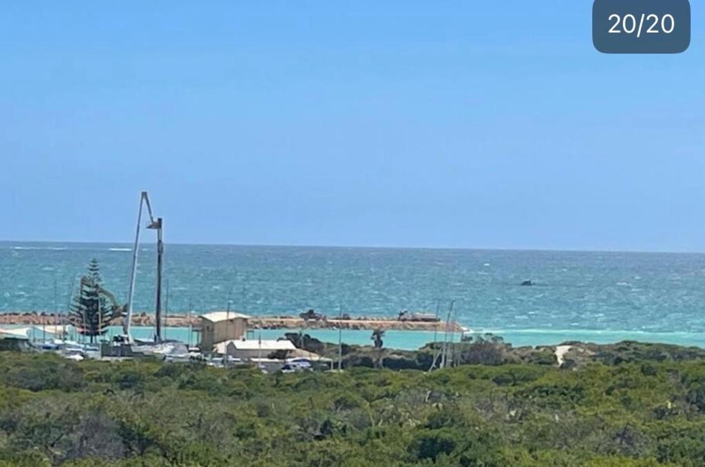 een uitzicht op een strand met de oceaan op de achtergrond bij Ocean Reef Vista in Perth
