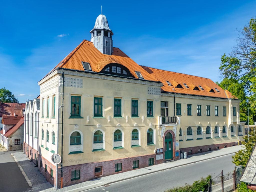 an old building with an orange roof on a street at Apartmány SRC in Nové Město pod Smrkem