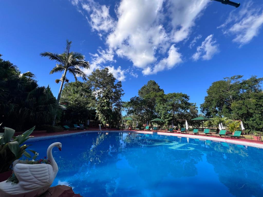 a swimming pool at a resort with a swan on it at Cabañas Rincón Andaluz in Puerto Iguazú