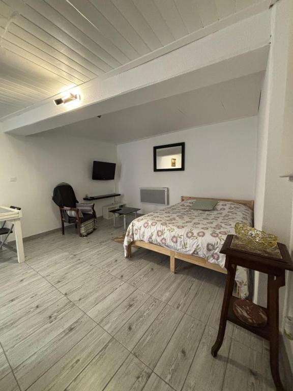 een slaapkamer met een bed en een bureau bij Studio agréable et paisible in Aubagne