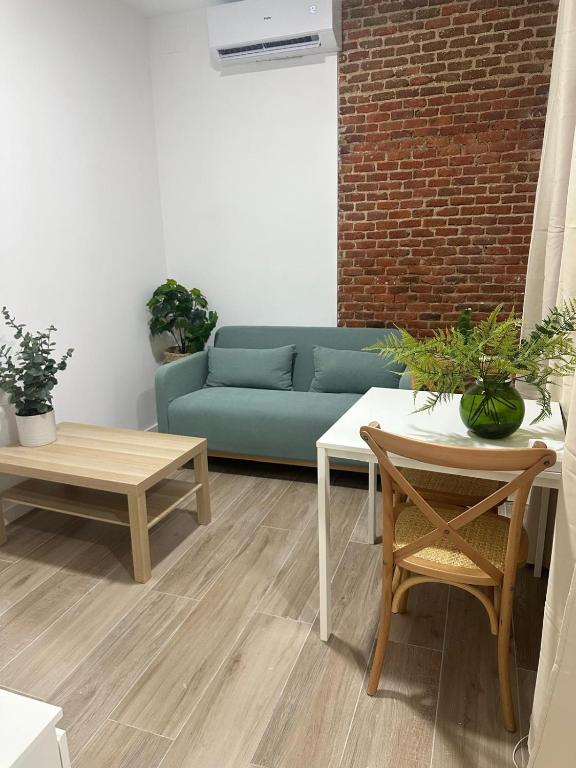 a living room with a blue couch and tables at La Casa de Mara in Madrid
