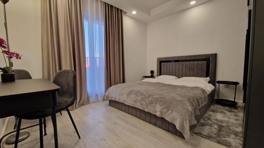 a hotel room with a bed and a desk and a desk at Sapphire Suite #pool&parking #Cosmopolis in Ştefăneştii de Sus