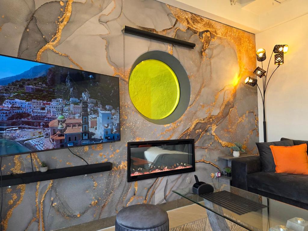 een woonkamer met een bank en een tv aan de muur bij Casa Del Mare in Kavala